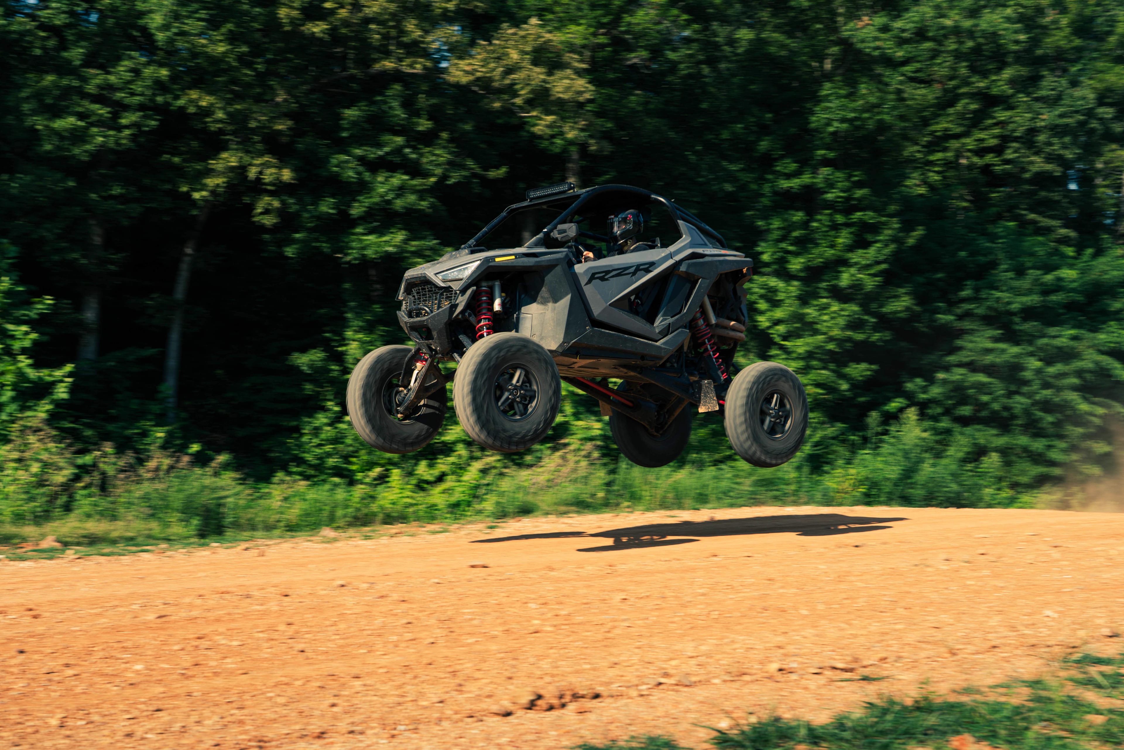 UTV jumping over a dirt mound