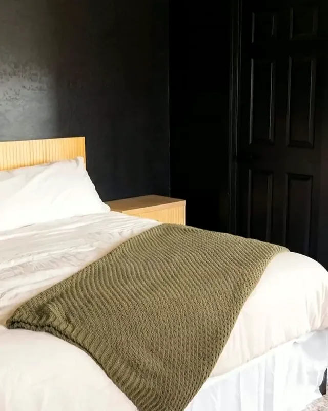Inside a Premium One Bed cabin: a king bed with a wood headboard, a leather chair by the window